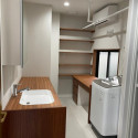 １階　洗面室<br />
物干しバーやリネン用の棚、家事用デスクを設置